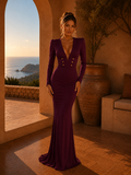 Woman in a deep purple gown standing in a sunlit room with ocean view