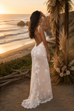 Woman in a floral dress standing on a beach with sunset and ocean view