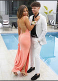 Two people in formal attire by a poolside.