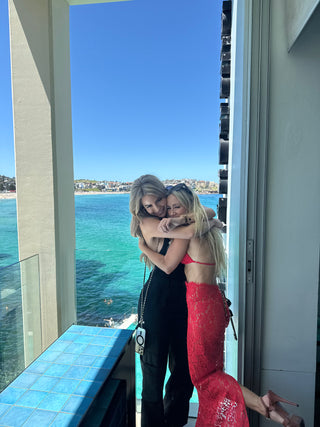 Beautiful model posing by the ocean wearing the Roses Are Red Set - HIRE by Amy Taylor Collection