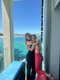 Beautiful model posing by the ocean wearing the Roses Are Red Set - HIRE by Amy Taylor Collection