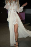 Person wearing a white lace dress with sheer overlay in an indoor setting