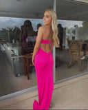 Woman in a bright pink dress standing in front of a glass door.