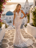 Woman in a white lace dress standing on a stone path with a scenic background