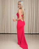 Woman in a red dress standing outdoors on a patio.